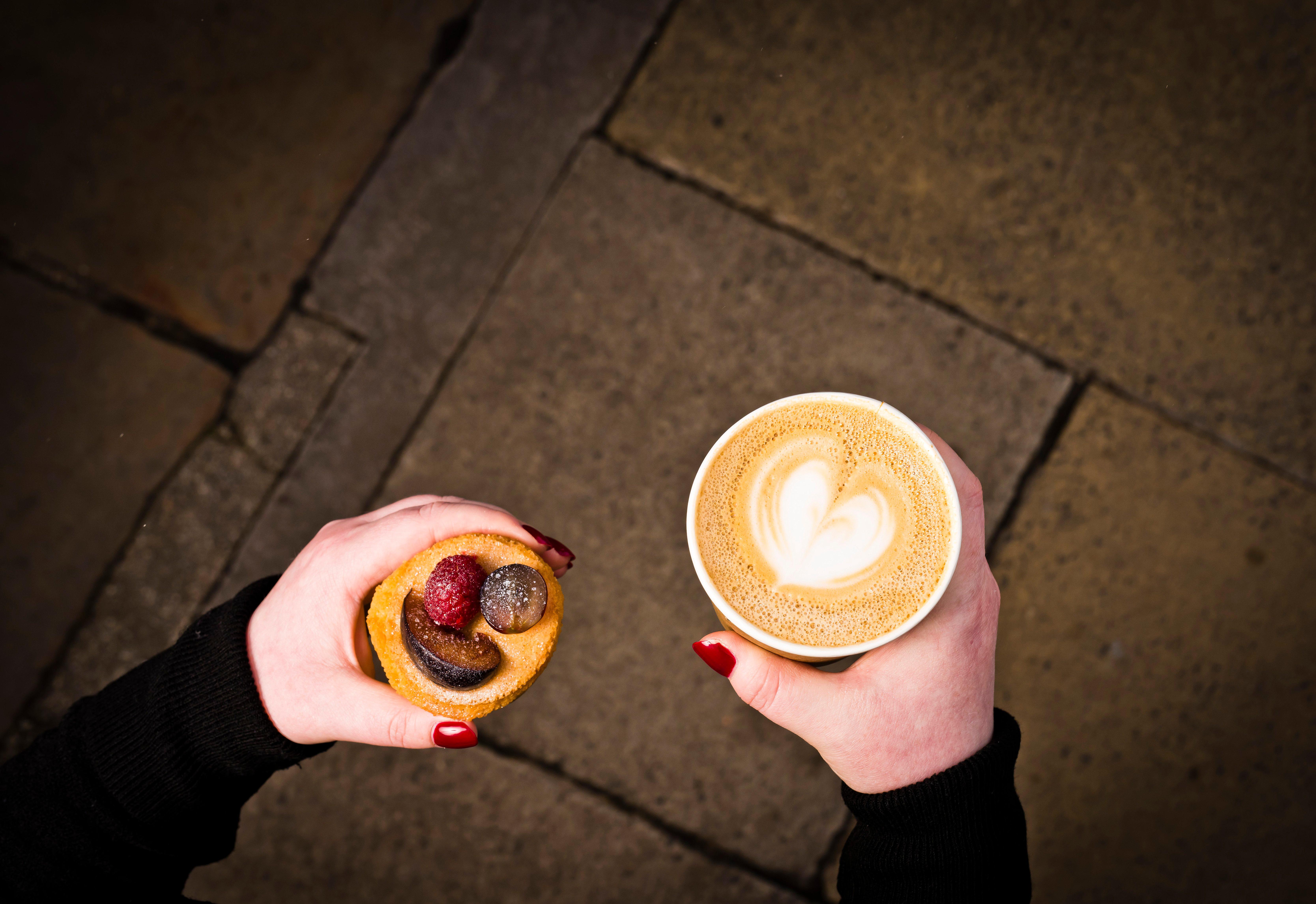 Hotel Intercontinental Edinburgh The George By Ihg Exteriér fotografie A woman holding a coffee and a doughnut